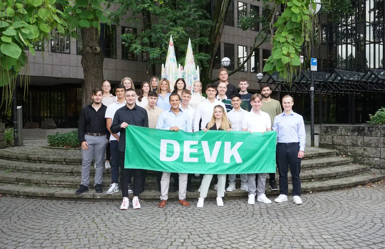 Azubis stehen vor DEVK-Zentrale