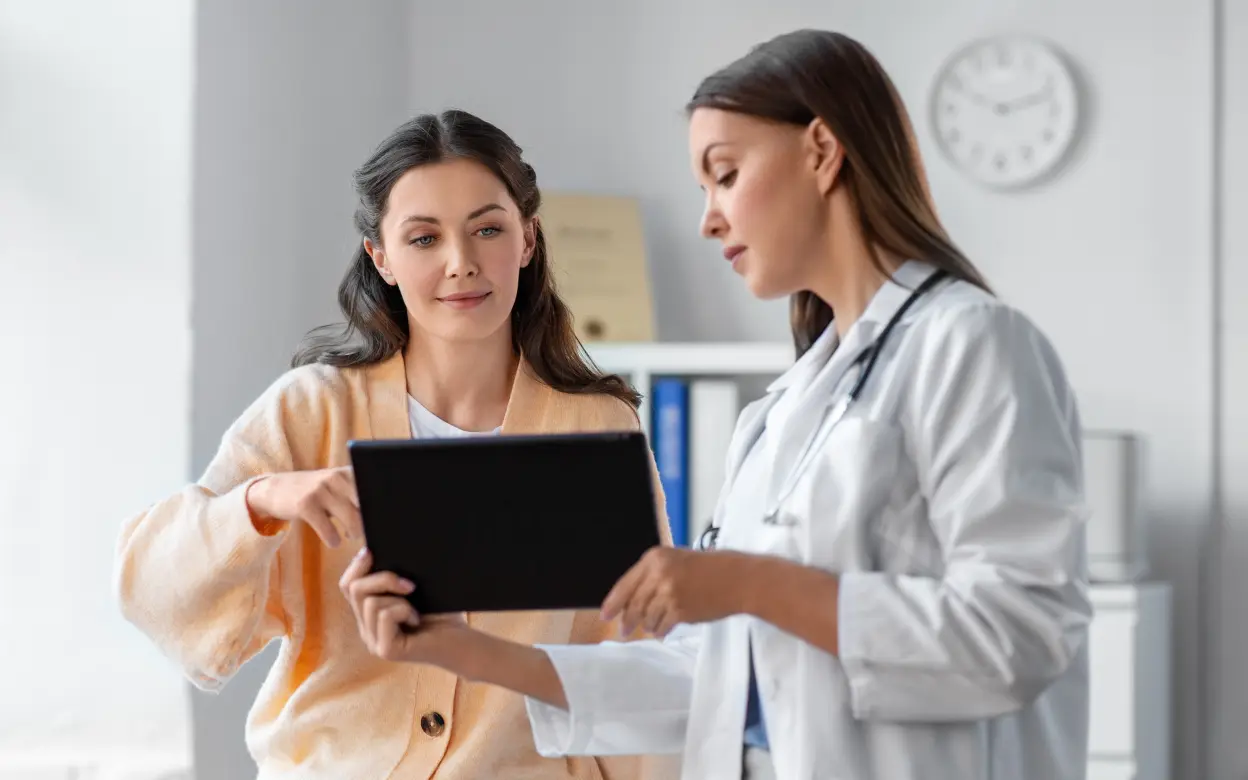 Ärztin berät Patientin mit Tablet