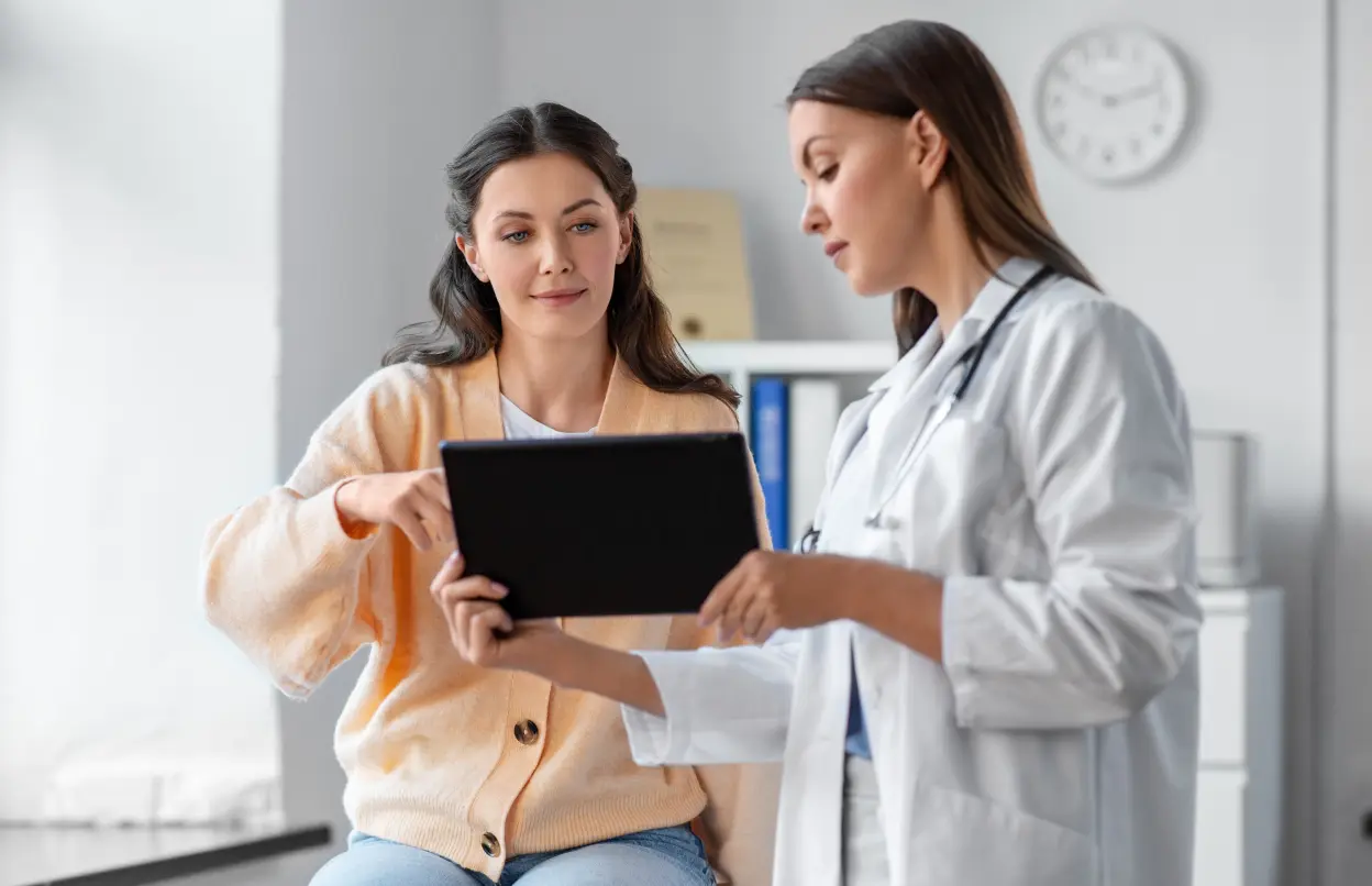 Ärztin berät Patientin mit Tablet