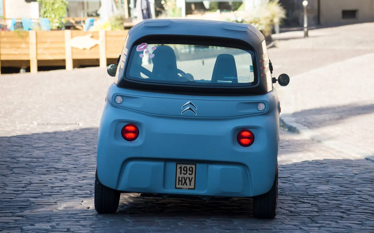 Blaues Mopedauto von hinten