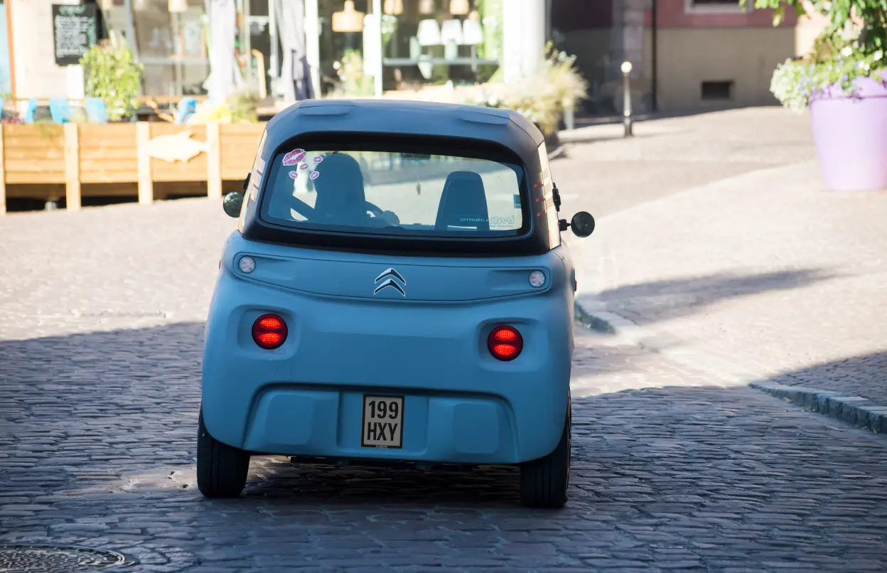 Blaues Mopedauto von hinten