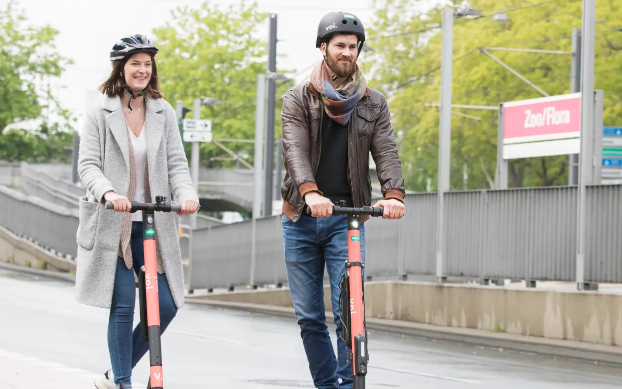 Mann und Frau auf E-Rollern