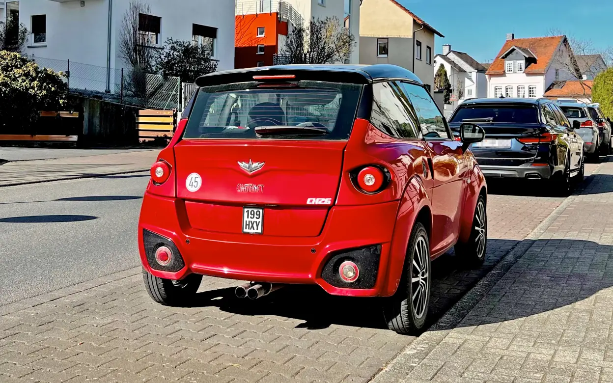 Rotes Mopedauto von hinten