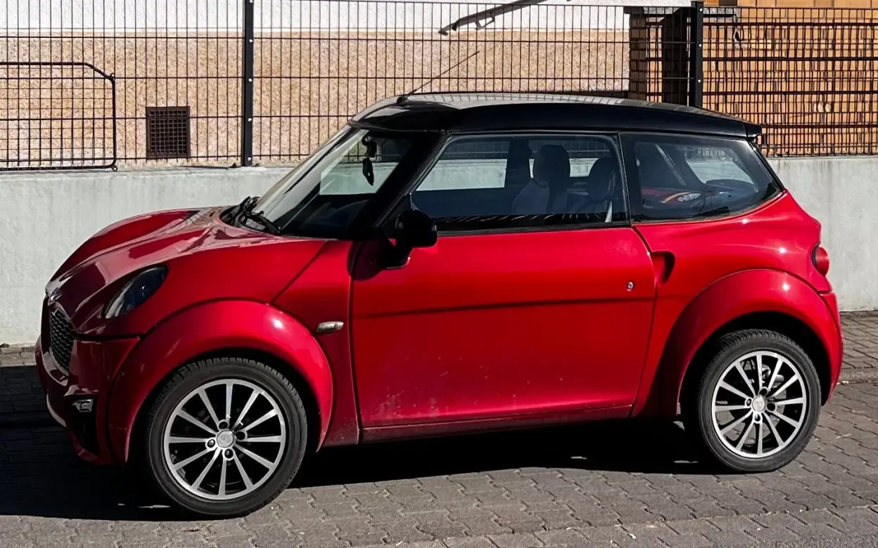 Rotes Mopedauto seitlich