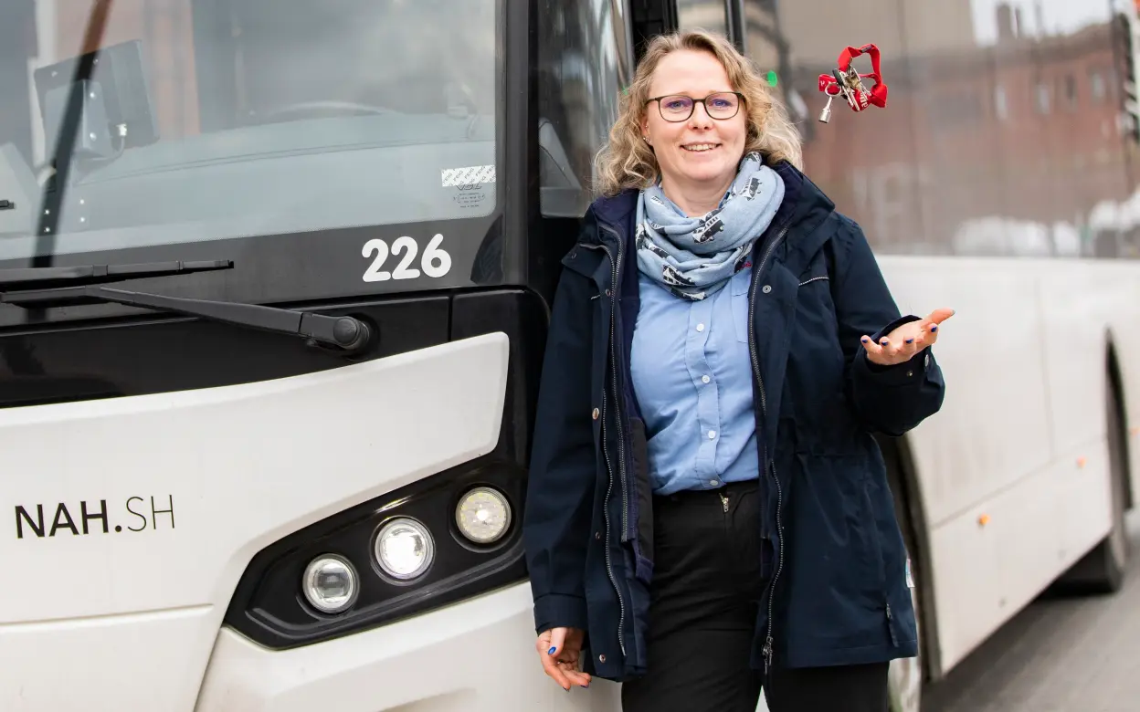 Busfahrerin lehnt an Bus