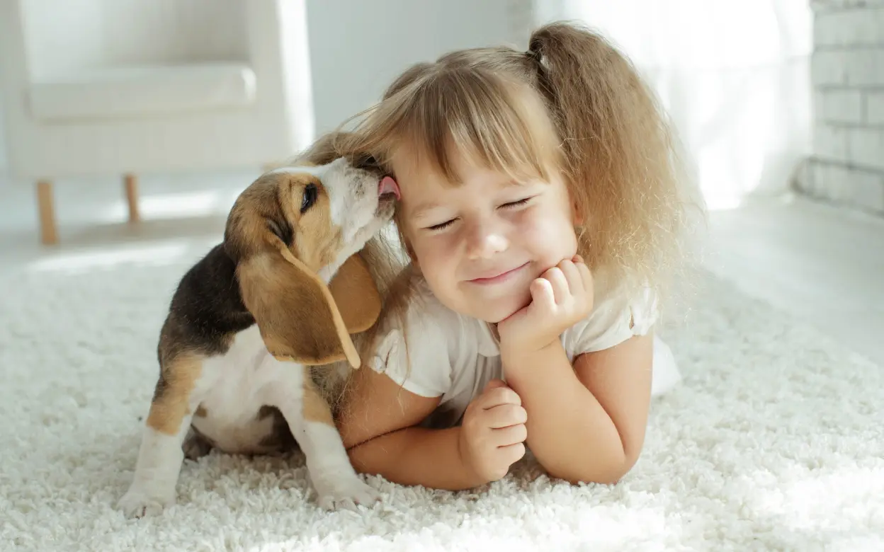 Mädchen kuschelt mit Welpe