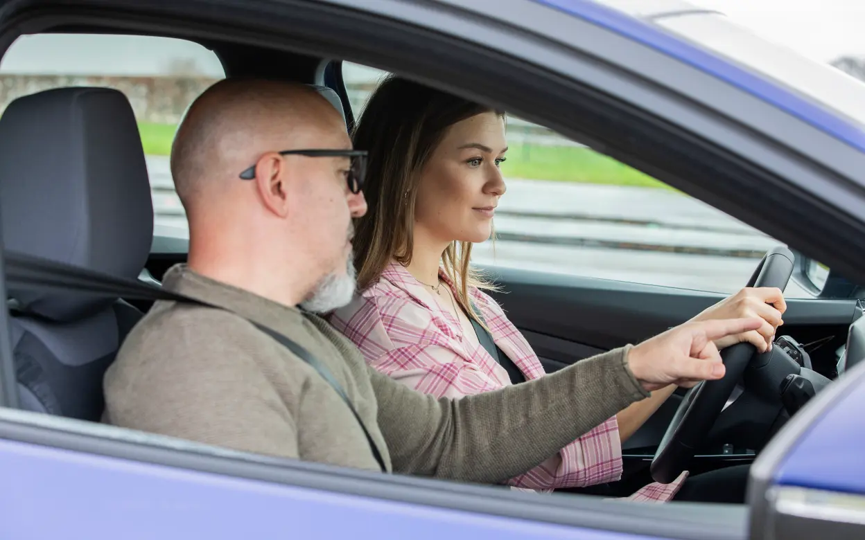 Zwei Menschen beim begleiteten Fahren im Auto.