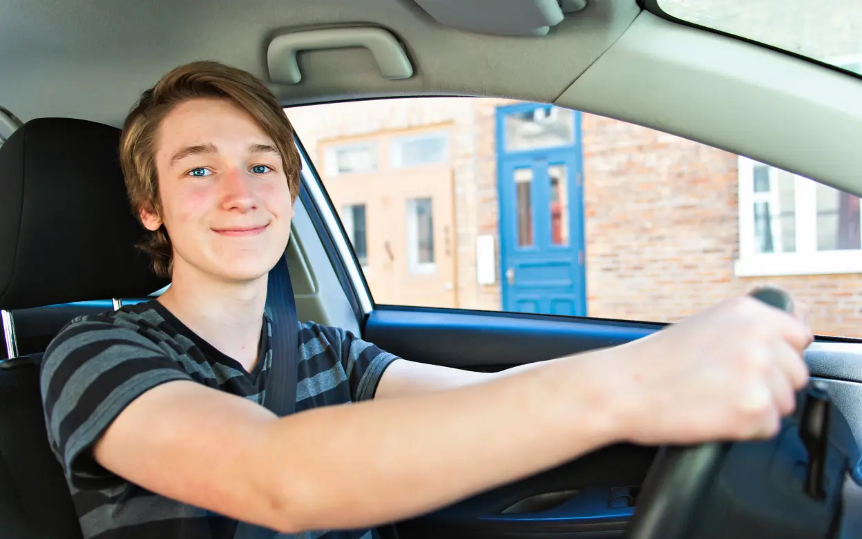 Ein Teenager sitzt am Steuer eines Autos