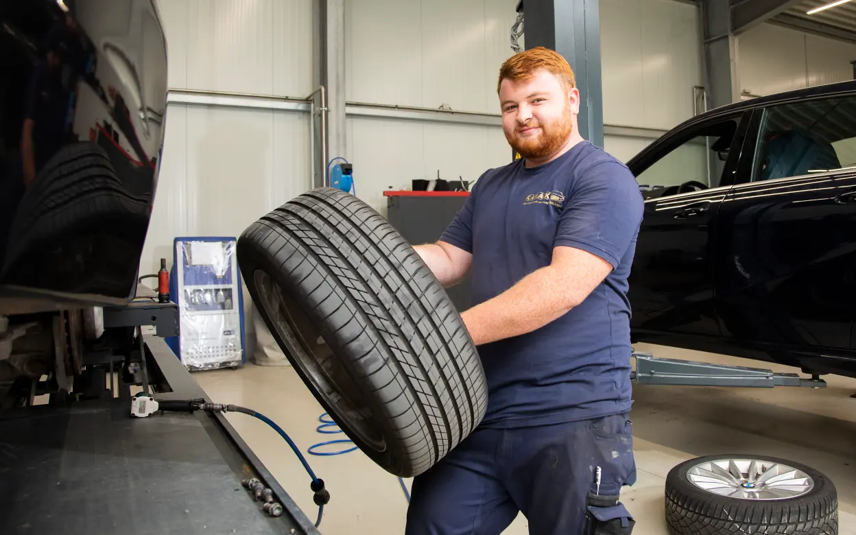 Mechaniker mit Autoreifen