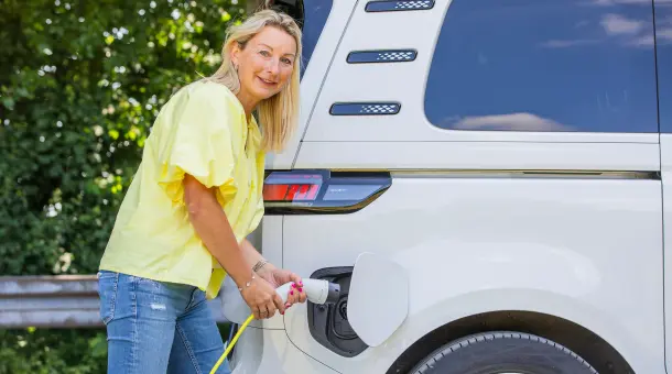 Eine Frau lädt ein E-Auto
