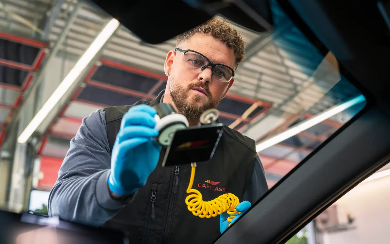 Mann repariert Windschutzscheibe