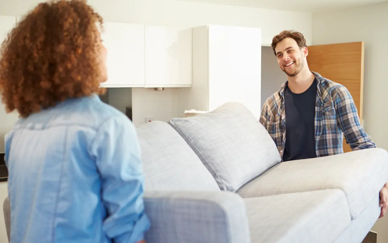 Paar trägt Sofa während Umzug