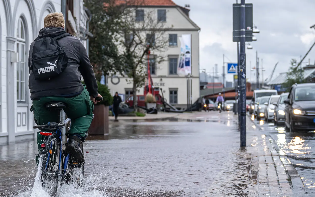 Fahrradfahrer fährt durch Hochwasser