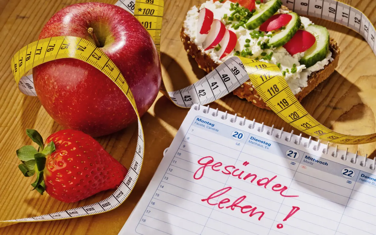 Maßband schlängelt sich um Obst und gesund belegtes Brot