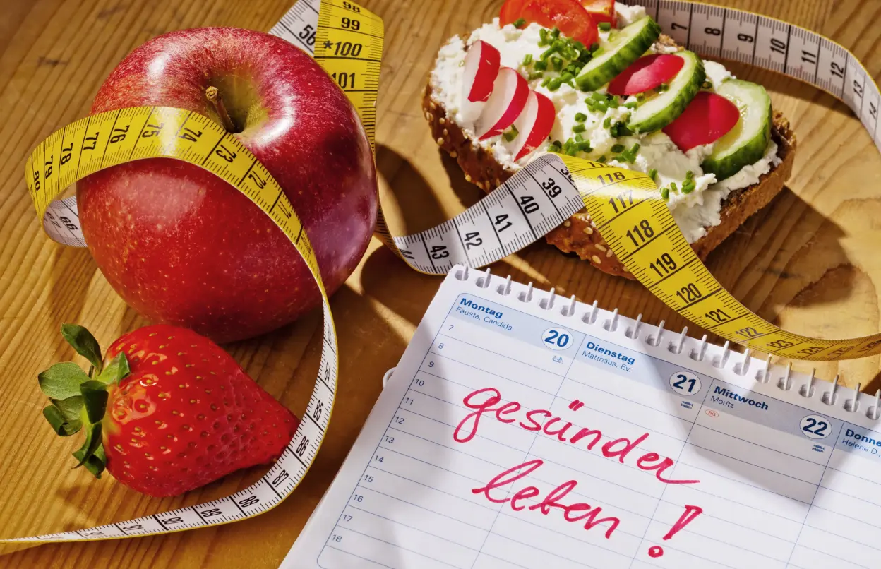 Maßband schlängelt sich um Obst und gesund belegtes Brot