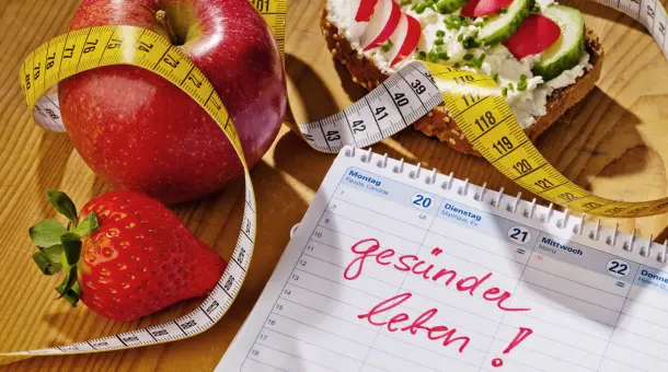 Maßband schlängelt sich um Obst und gesund belegtes Brot