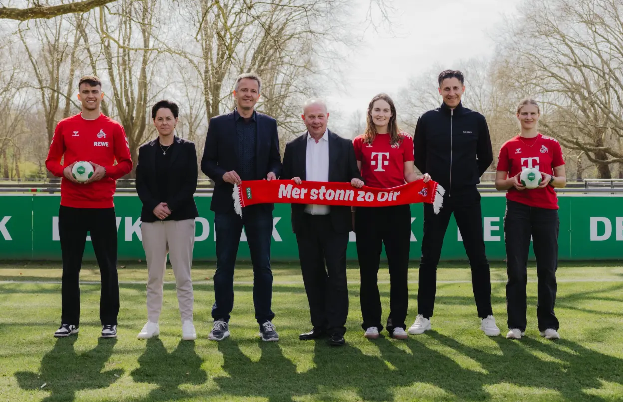 DEVK-Vorstandsvorsitzender Gottfried Rüßmann mit Funktionären und Spieler:innen des 1. FC Köln