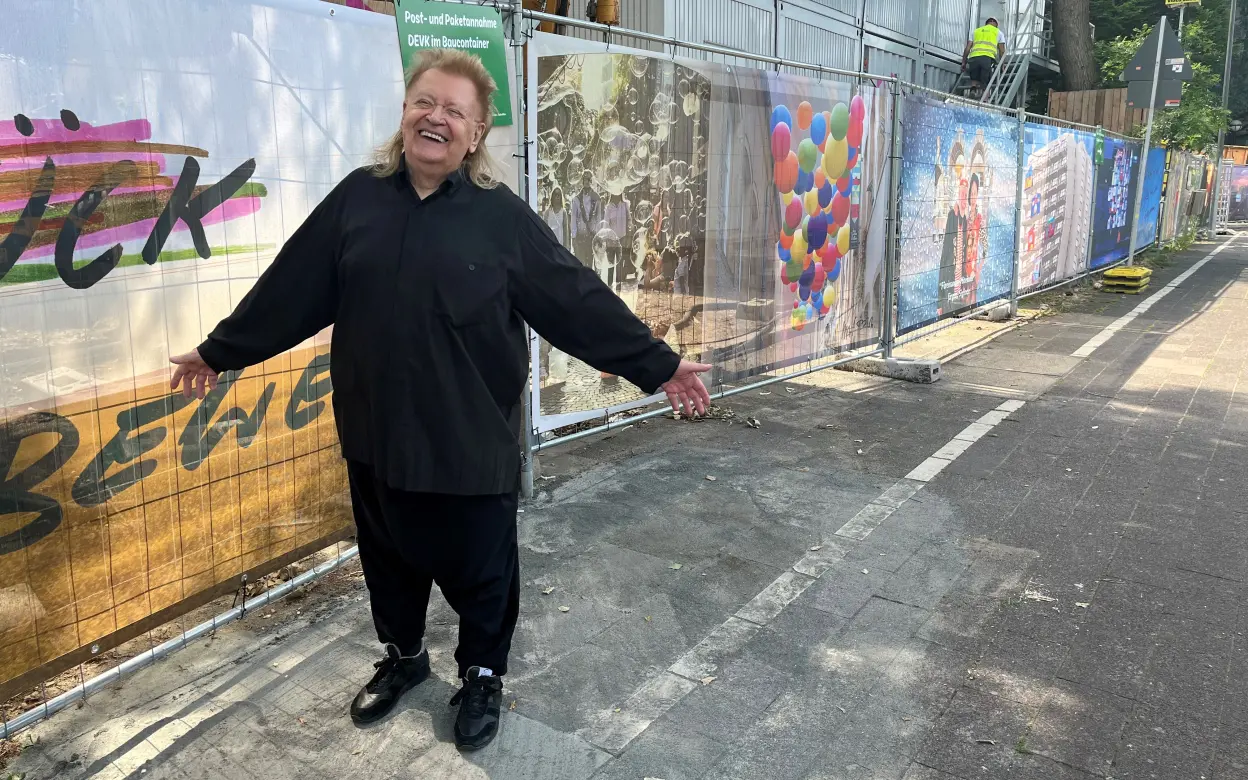 Künstler HA Schult vor Bauzaun an der DEVK Zentrale 