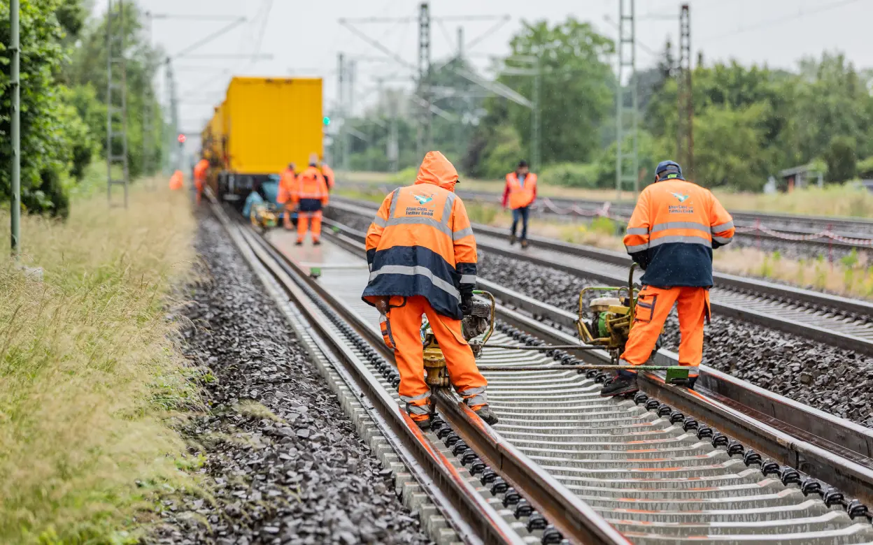 Mehrere Personen führen Gleisarbeiten durch