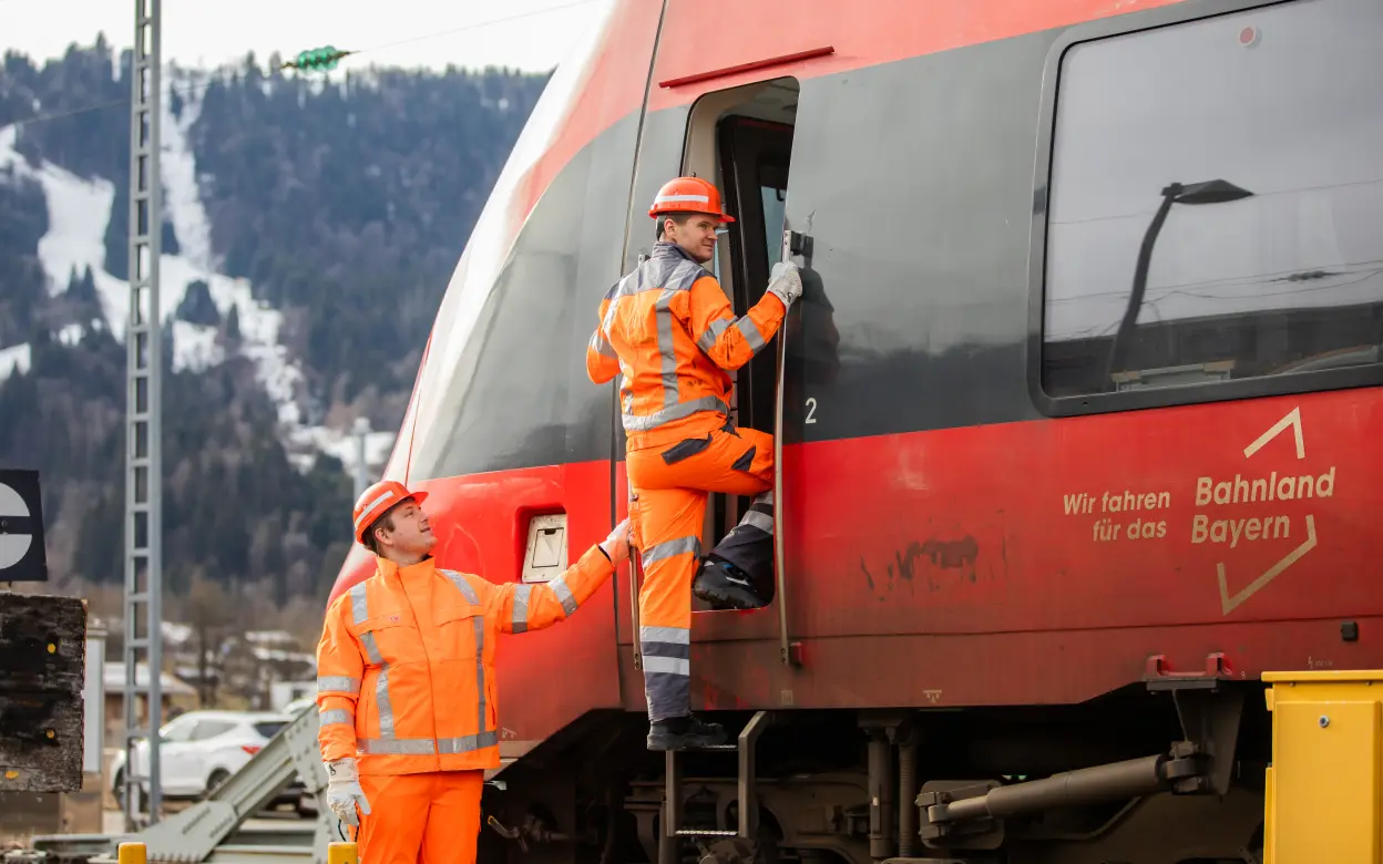 Bahnmitarbeiter steigen in einen Zug ein