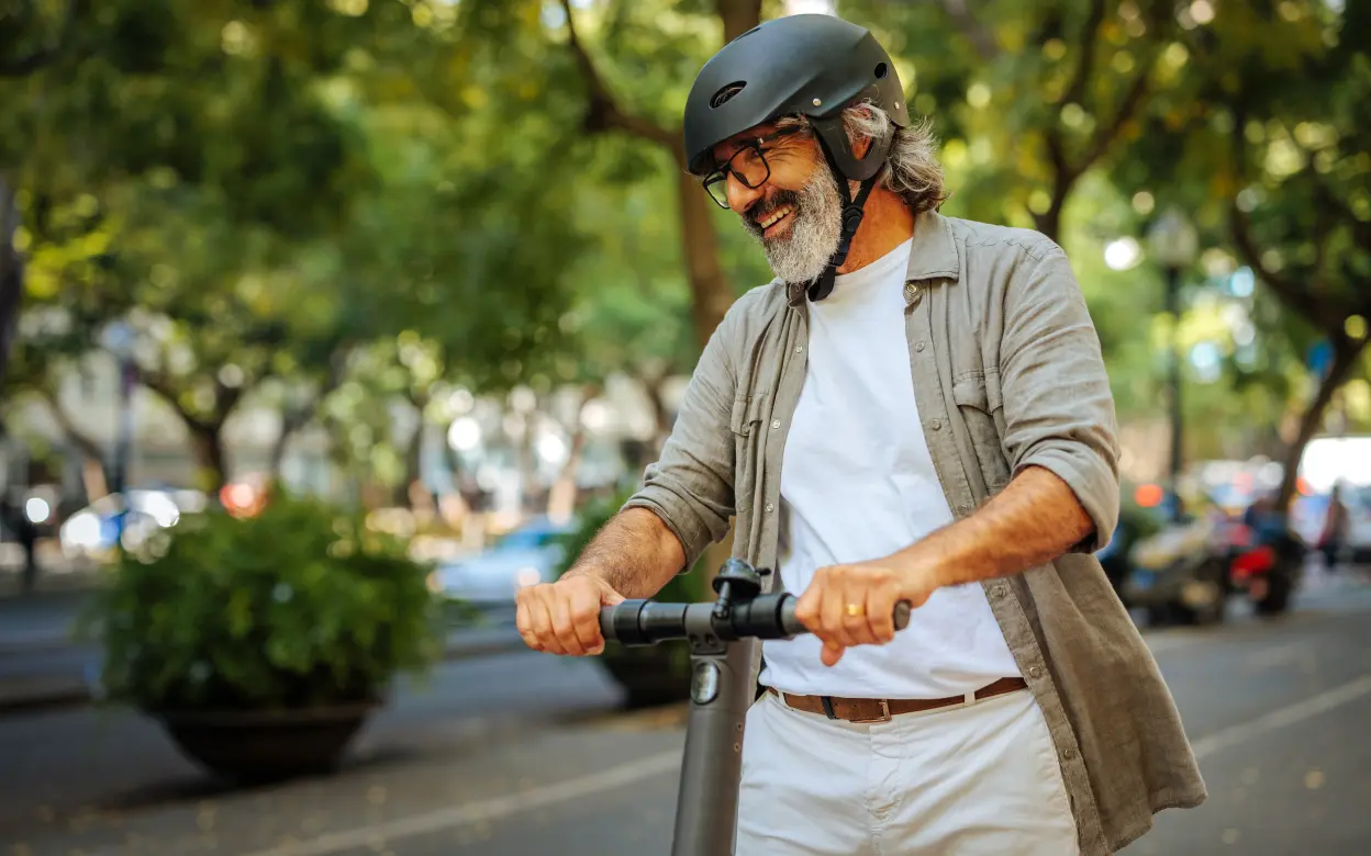 Mann mit Helm auf E-Scooter