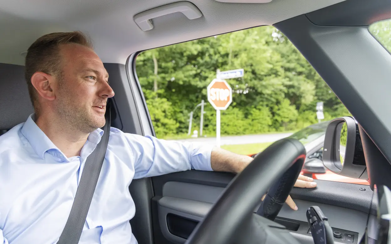 Mann sitzt am Steuer eines E-Autos