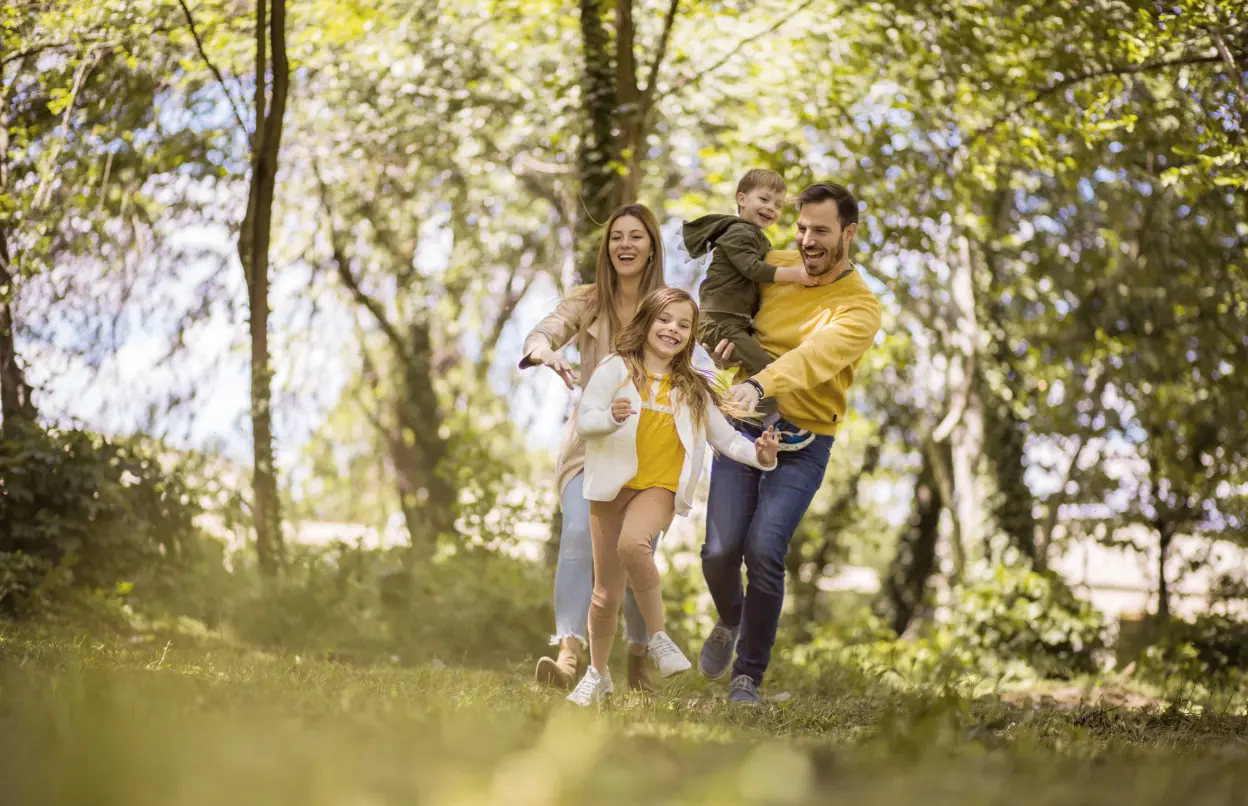 Fröhliche Familie spaziert gemeinsam durch den Wald