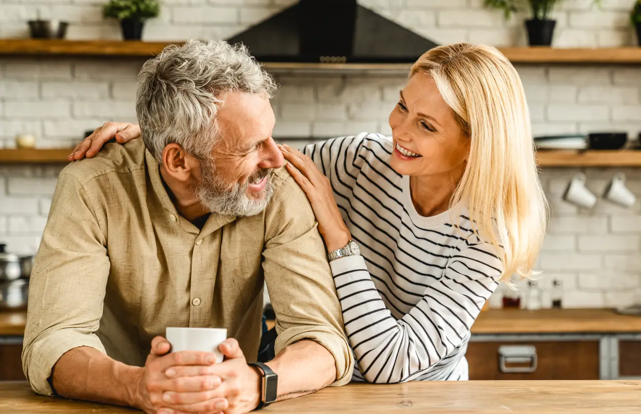 Paar steht gutgelaunt zusammen in der Küche