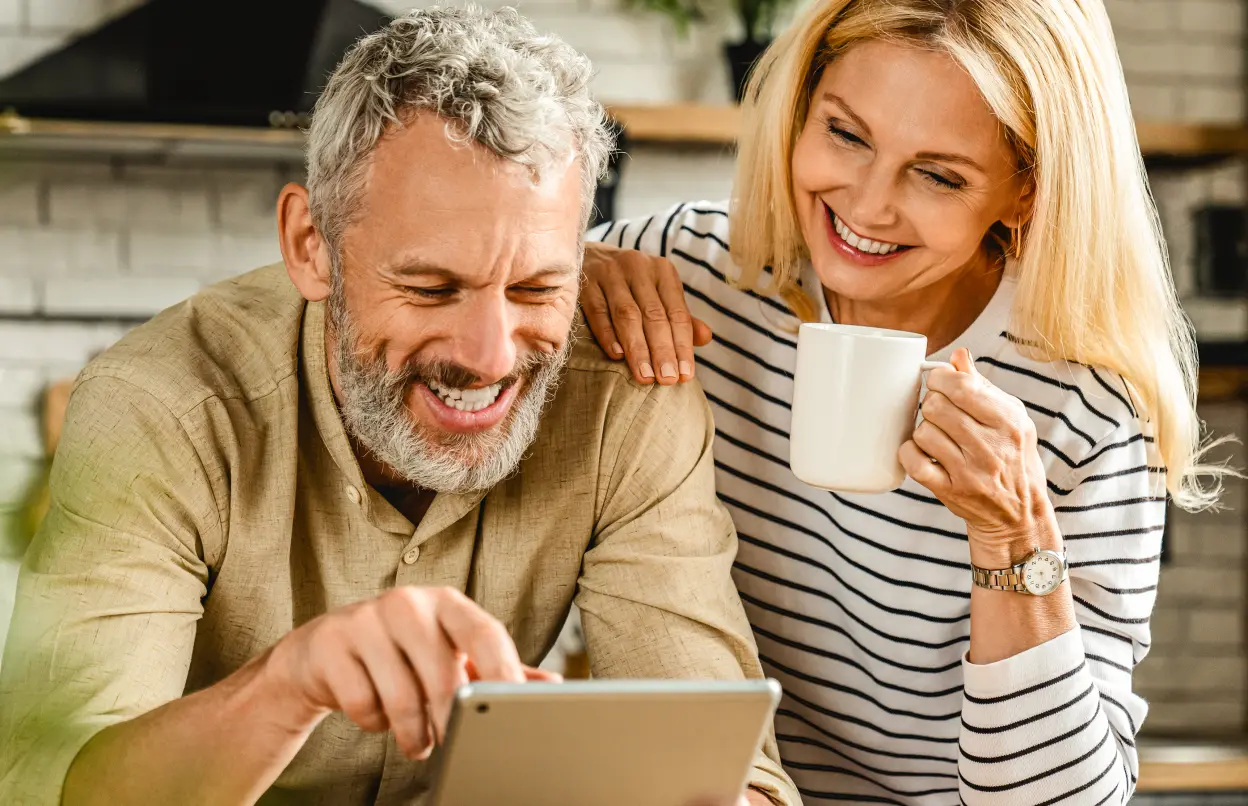 Paar schaut in Küche gemeinsam auf ein Tablet