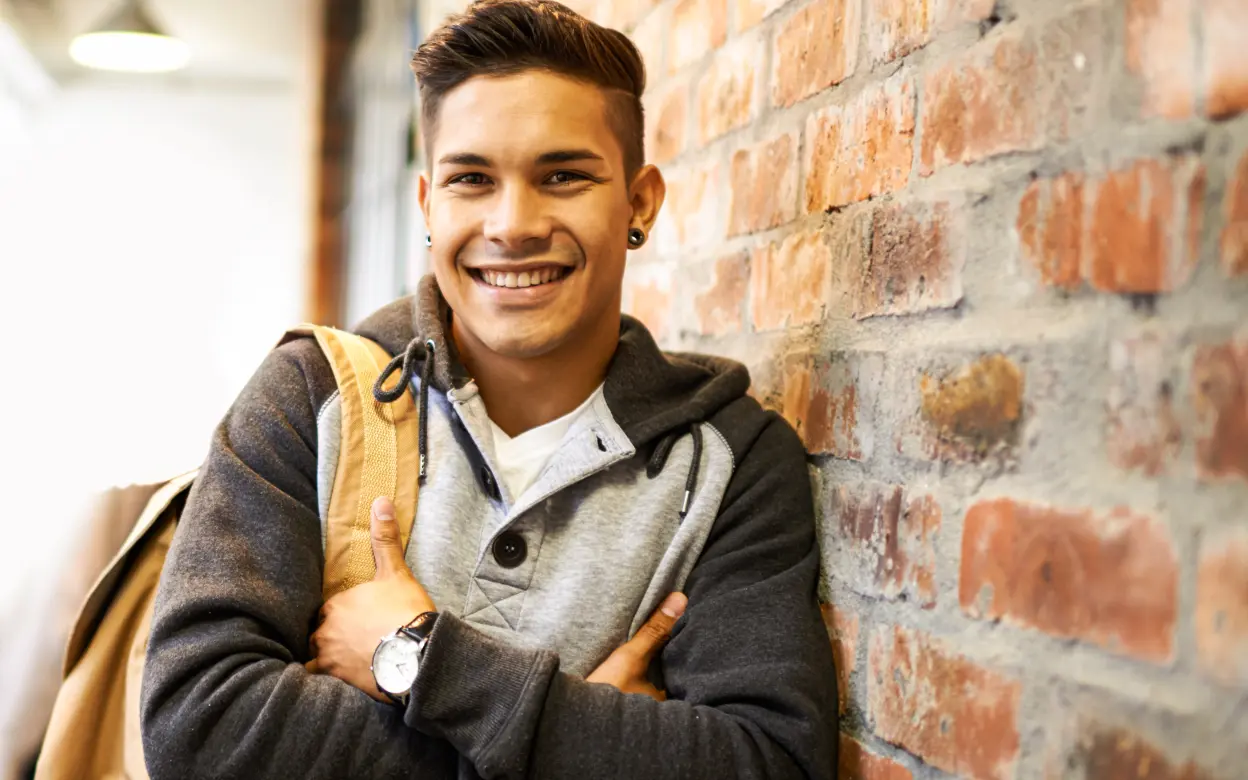 Junger Mann schaut lächelnd in die Kamera