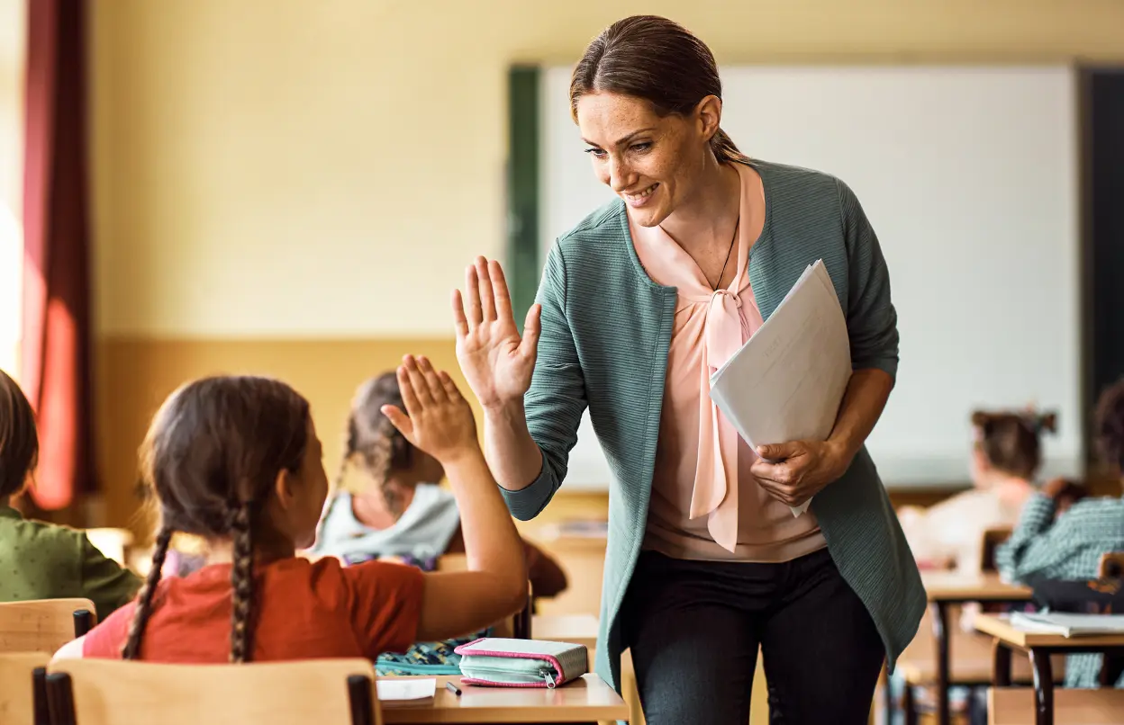 Lehrerin klatscht mit Schülerin ein