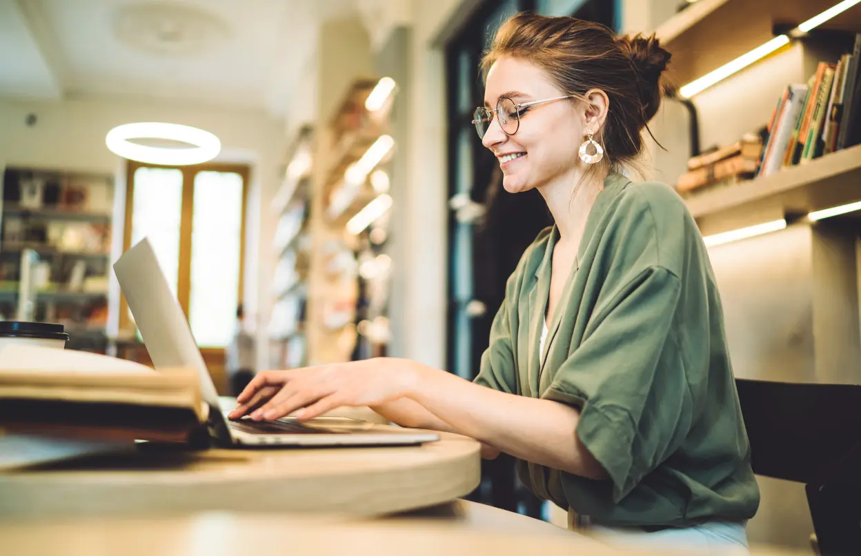 Junge Frau arbeitet motiviert am Laptop