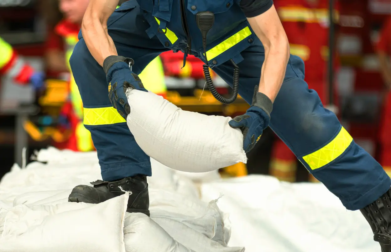 Mann trifft Vorkehrungen gegen Elementarschäden mit Sandsäcken