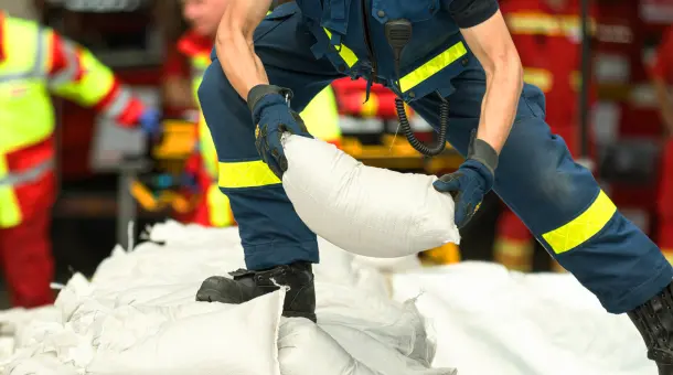 Mann trifft Vorkehrungen gegen Elementarschäden mit Sandsäcken