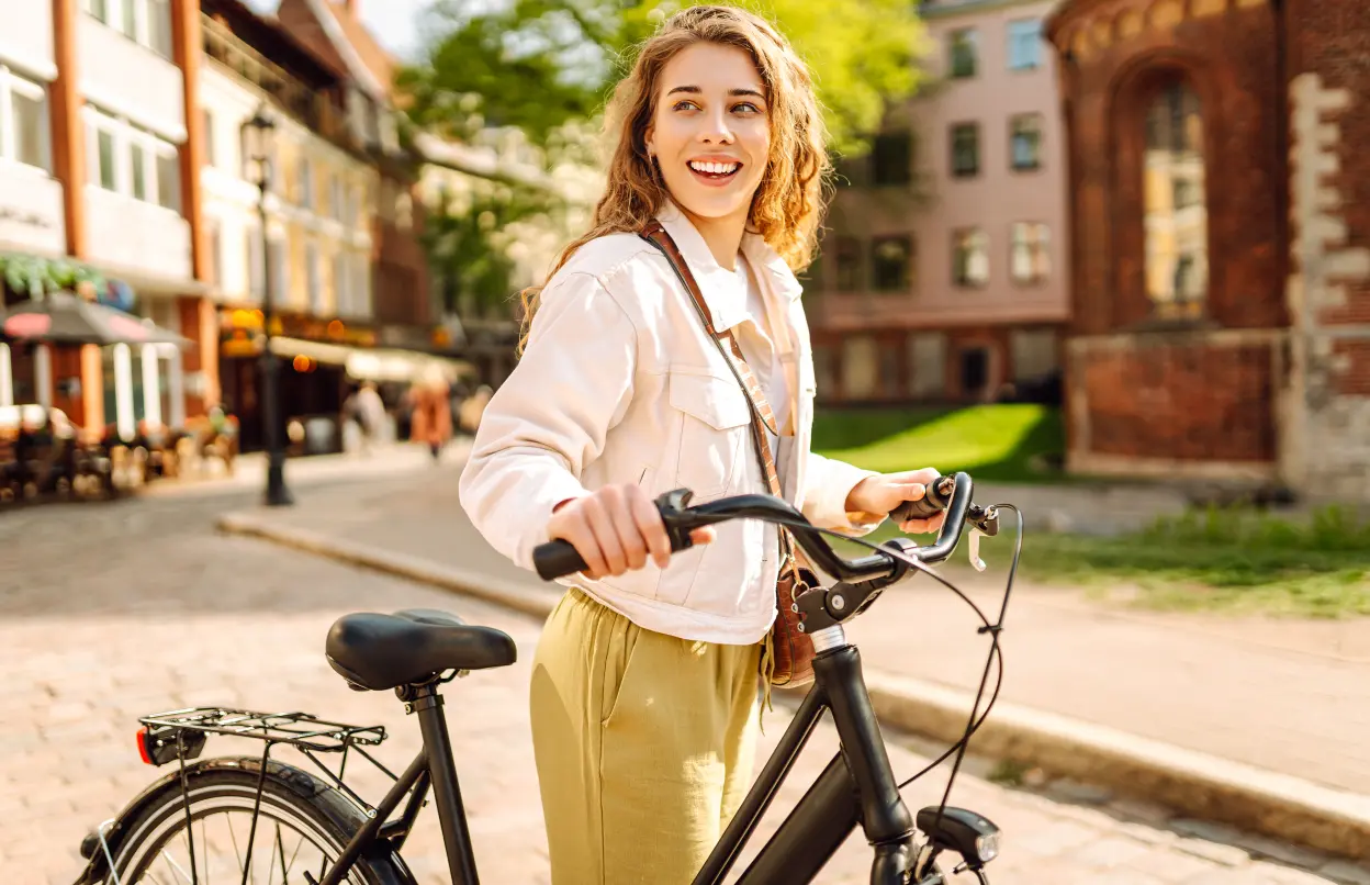 Eine Frau mit Fahrrad in der Stadt.