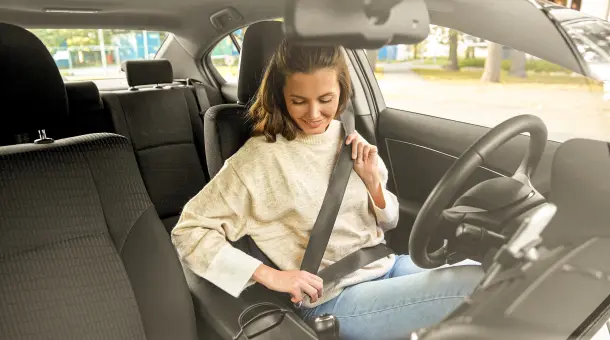 Frau schnallt sich im Auto an