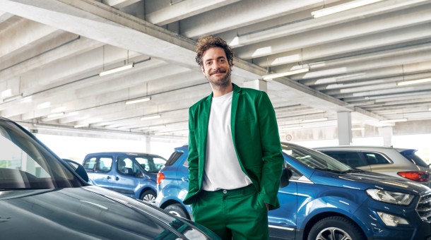 Ein Mann steht in einem Parkhaus vor Autos.