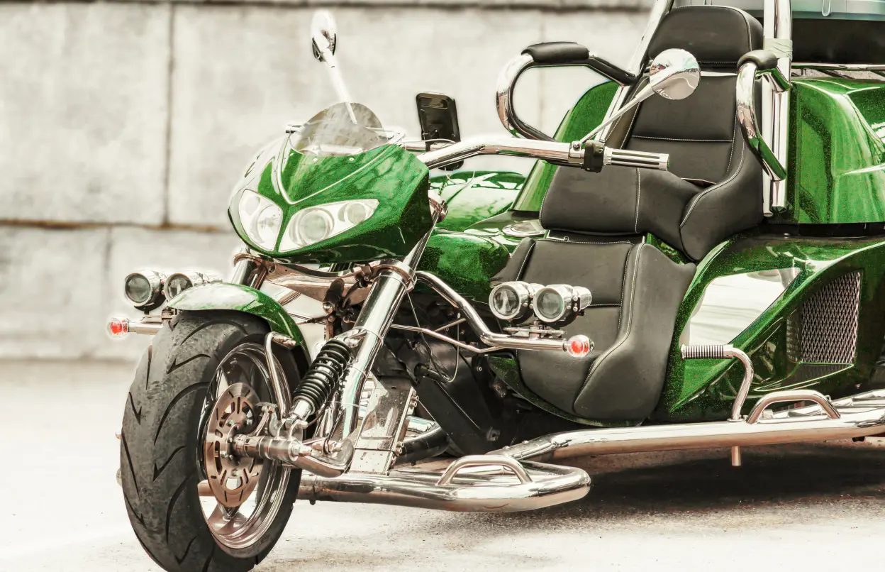 Ein grünes Trike steht vor einer Wand.