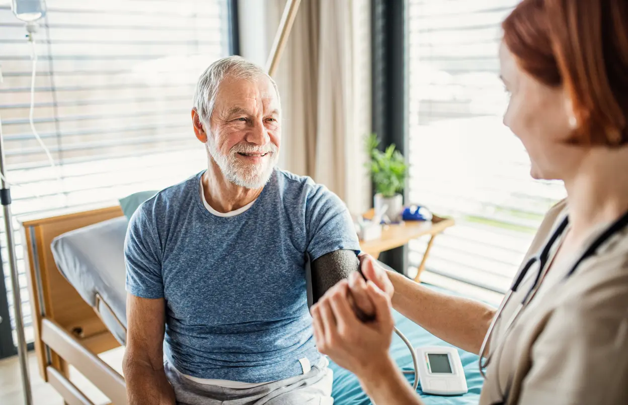 Ärztin misst Blutdruck bei einem Patienten