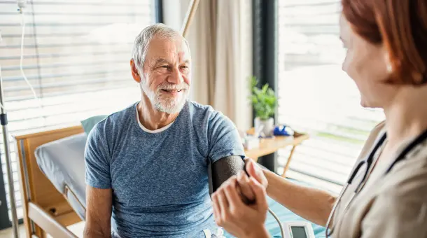 Ärztin misst Blutdruck bei einem Patienten