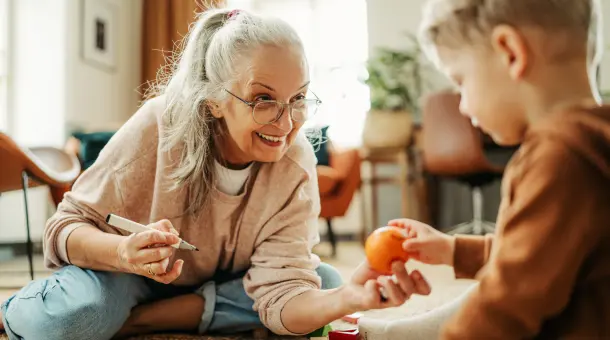 Oma reicht Enkelkind eine Mandarine