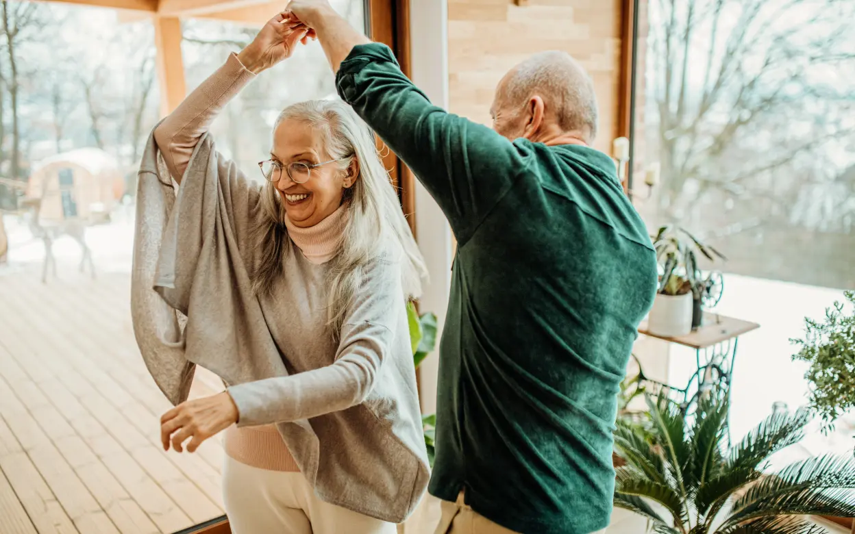 Älteres Ehepaar tanzt im Wohnzimmer