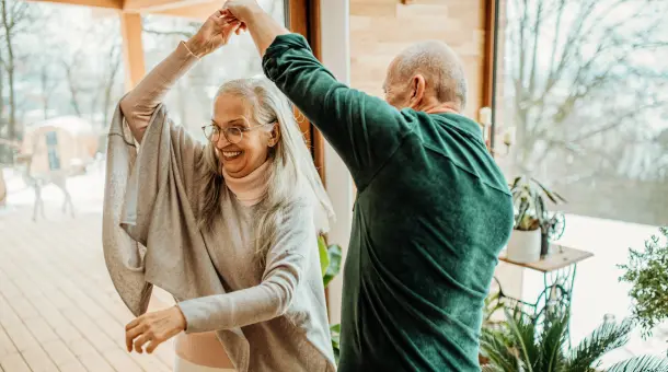 Älteres Ehepaar tanzt im Wohnzimmer