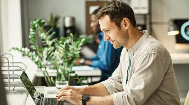 Mann arbeitet konzentriert am Laptop