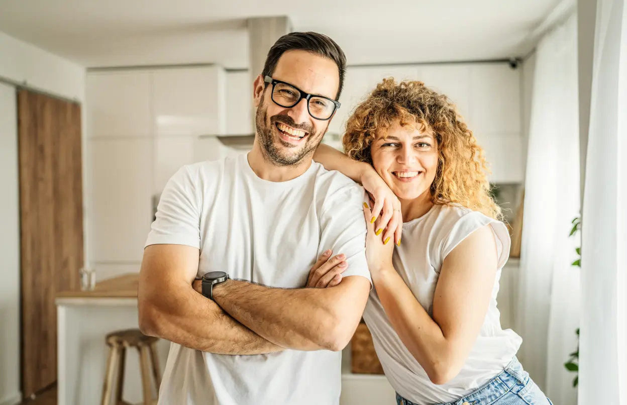 Glücklich lächelndes Paar steht in Küche