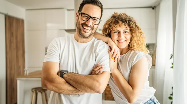 Glücklich lächelndes Paar steht in Küche