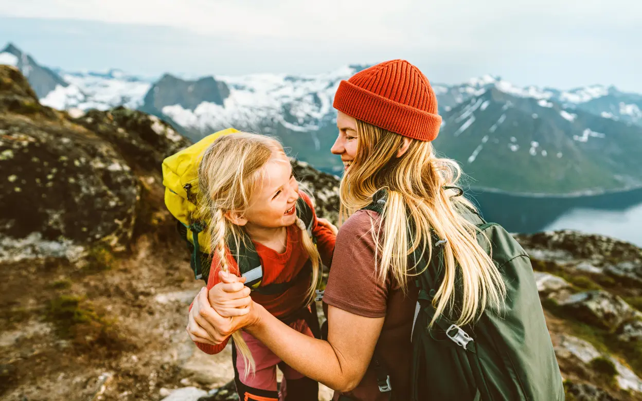 Frau wandert mit Kind auf Berg