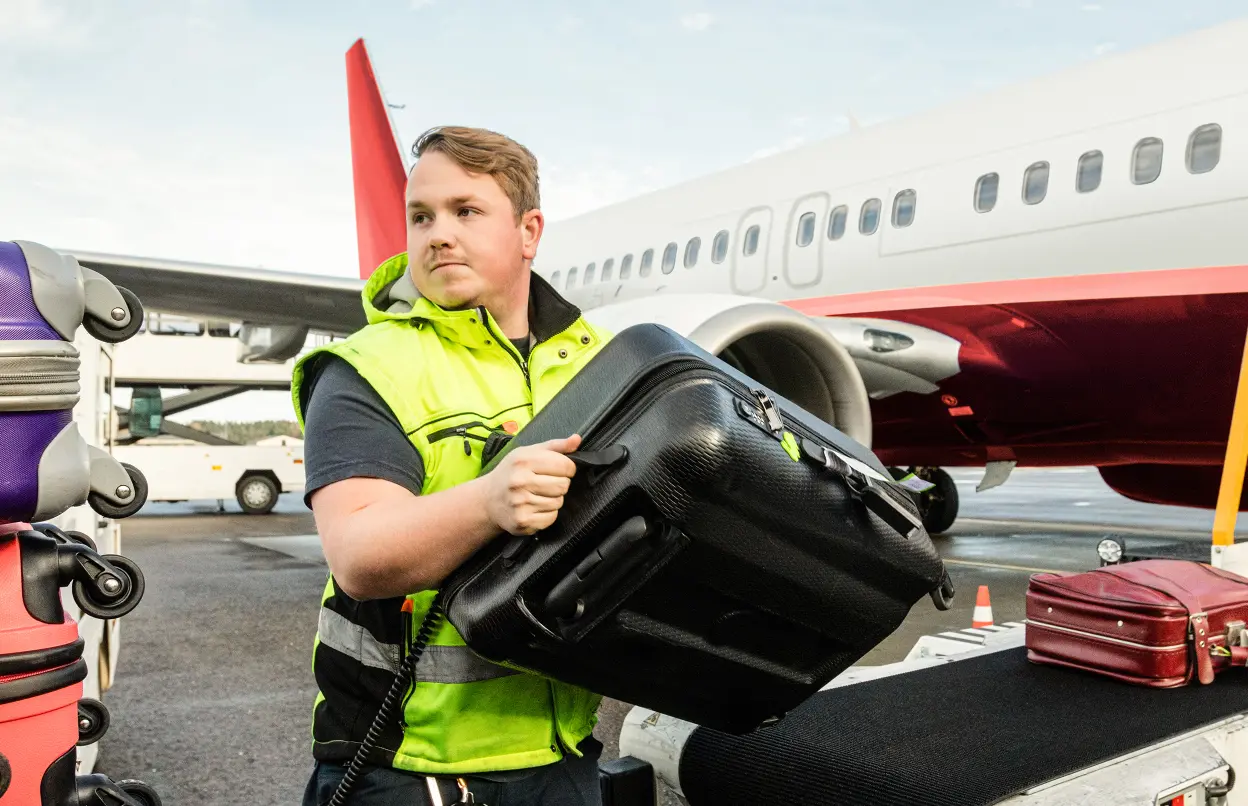 Mann verlädt Koffer am Flughafen