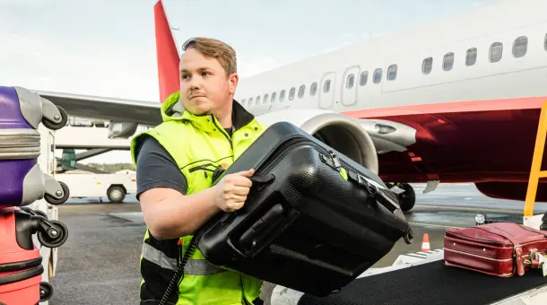 Mann verlädt Koffer am Flughafen