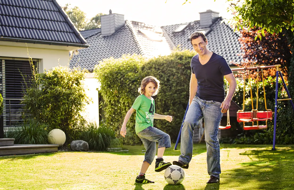 Vater und Sohn spielen im Garten Fußball
